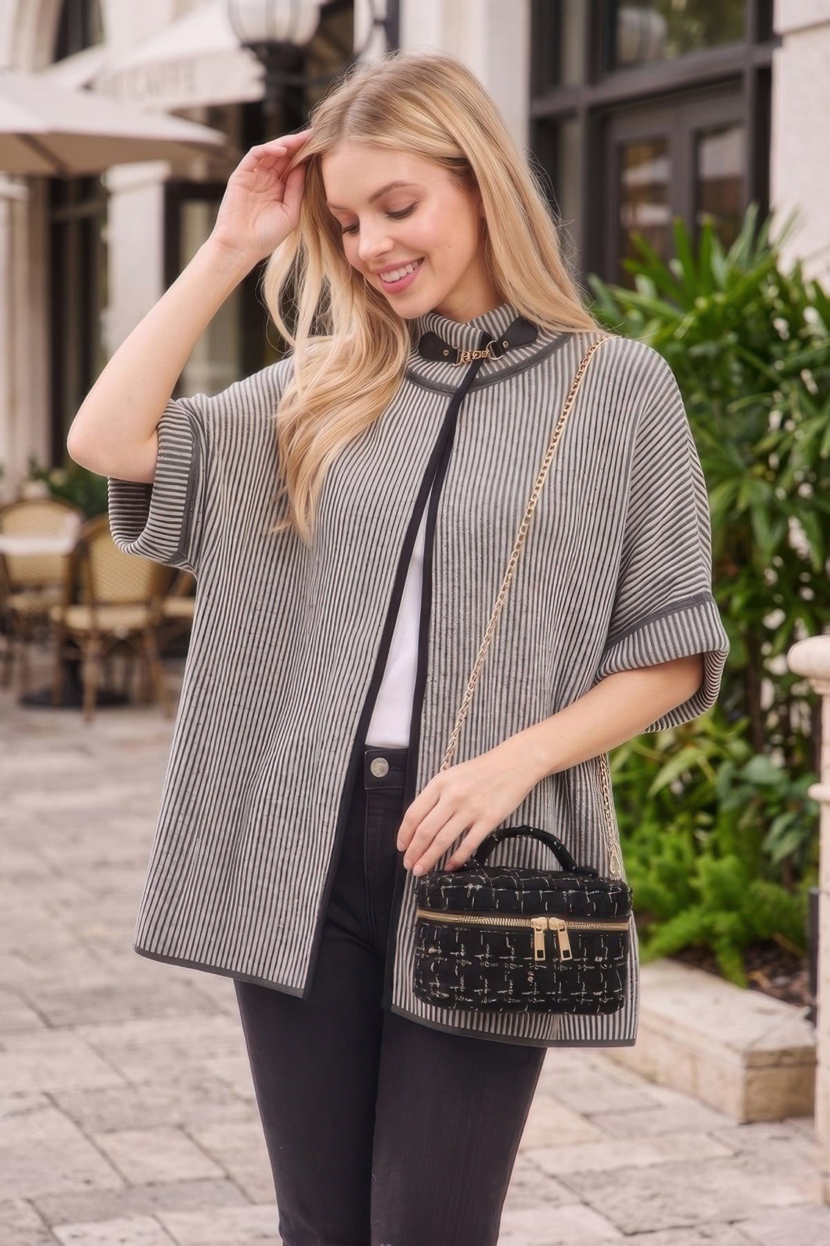 Black tweed vanity bag with top handle and chain strap worn crossbody
