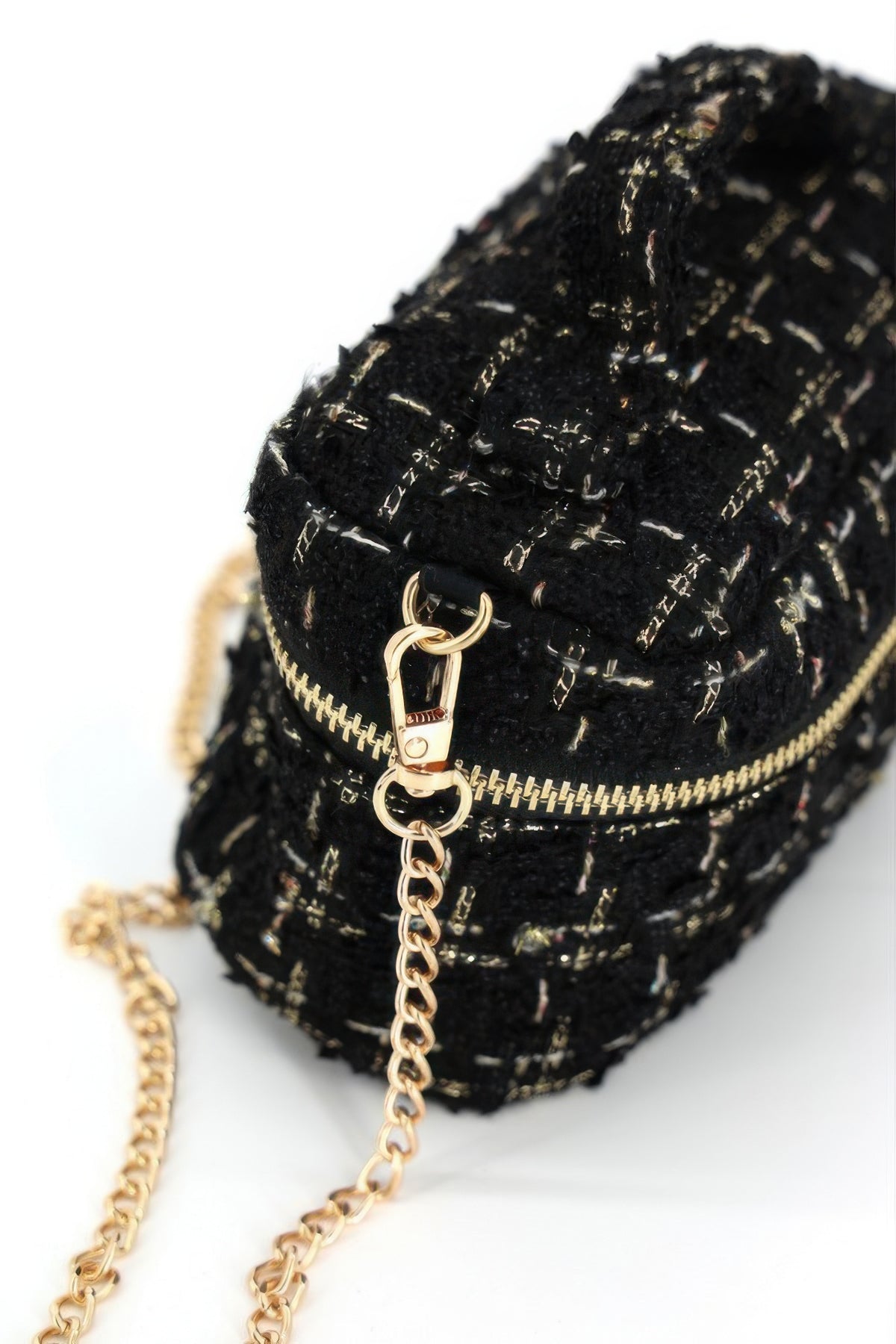 Close-up of black tweed bag zipper, chain attachment and woven texture