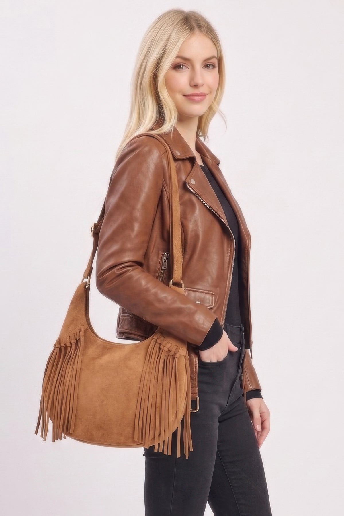 Model carrying the Camel Western faux suede fringe hobo bag with adjustable strap