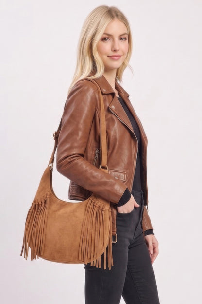 Model carrying the Camel Western faux suede fringe hobo bag with adjustable strap