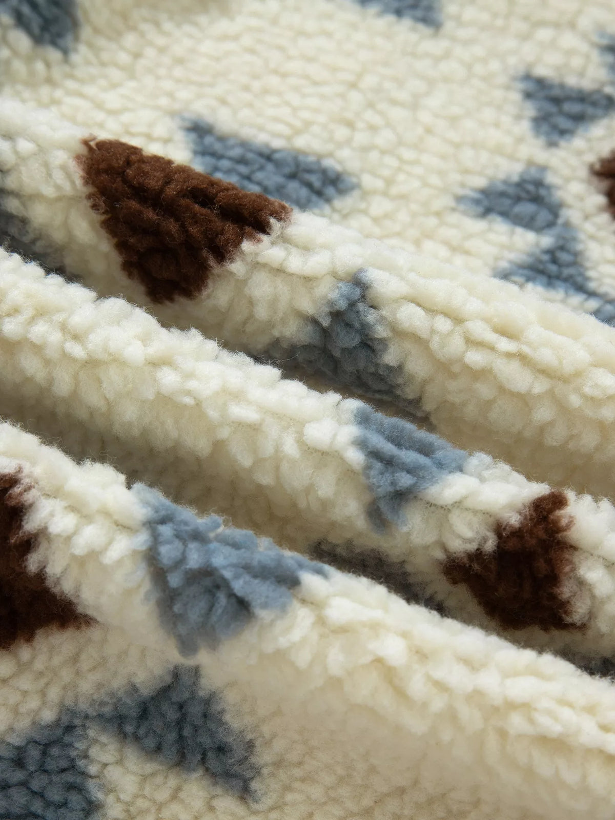 Close-up of the beige, blue and brown sherpa-textured sweatshirt fabric.