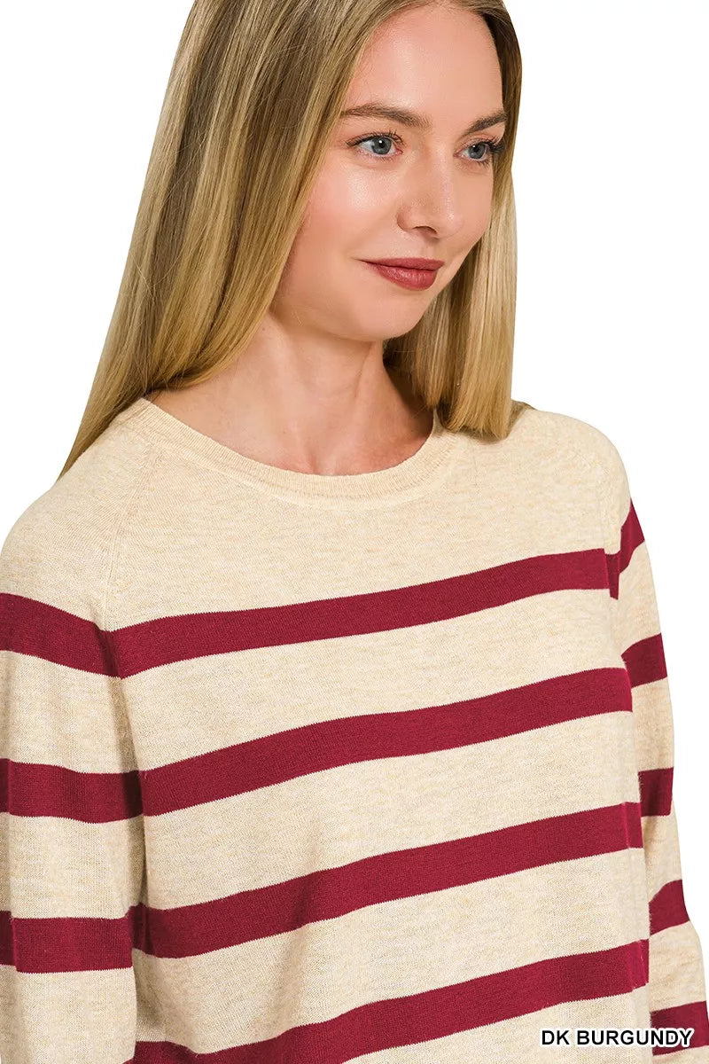 Angled front view of the oatmeal-and-burgundy striped long-sleeve sweater.