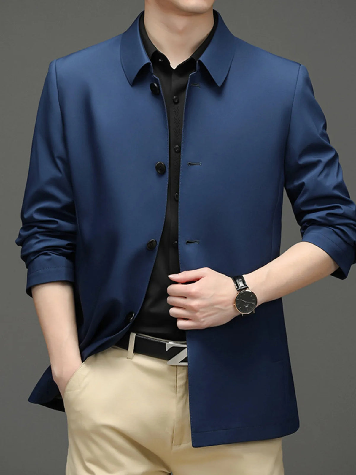 Blue button-front jacket with a pointed collar, styled over a separate shirt and trousers; belt and watch are not included.
