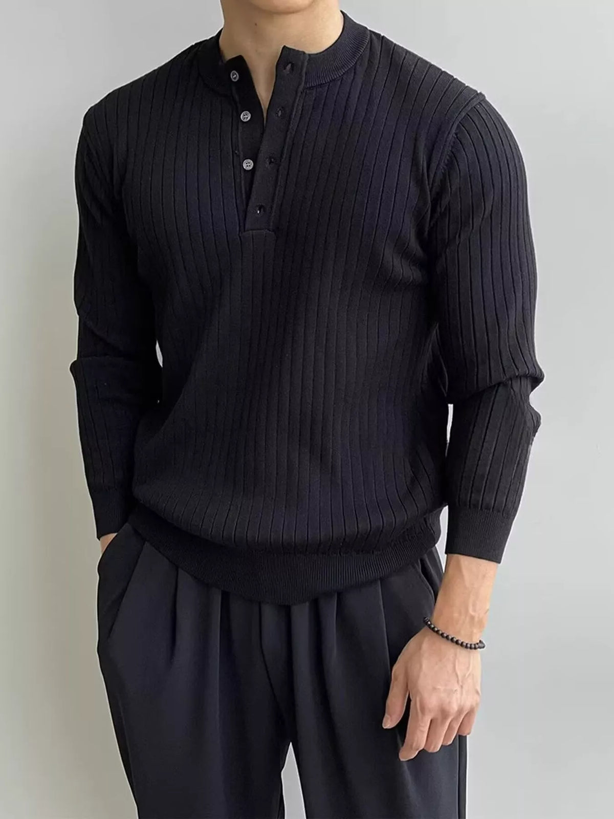 Black ribbed long-sleeve knit top with button detailing, modelled front view. One top only; styling pieces not included.