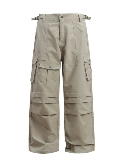 Grey wide-leg cargo trousers with flap pockets and waist buckle tabs, front view