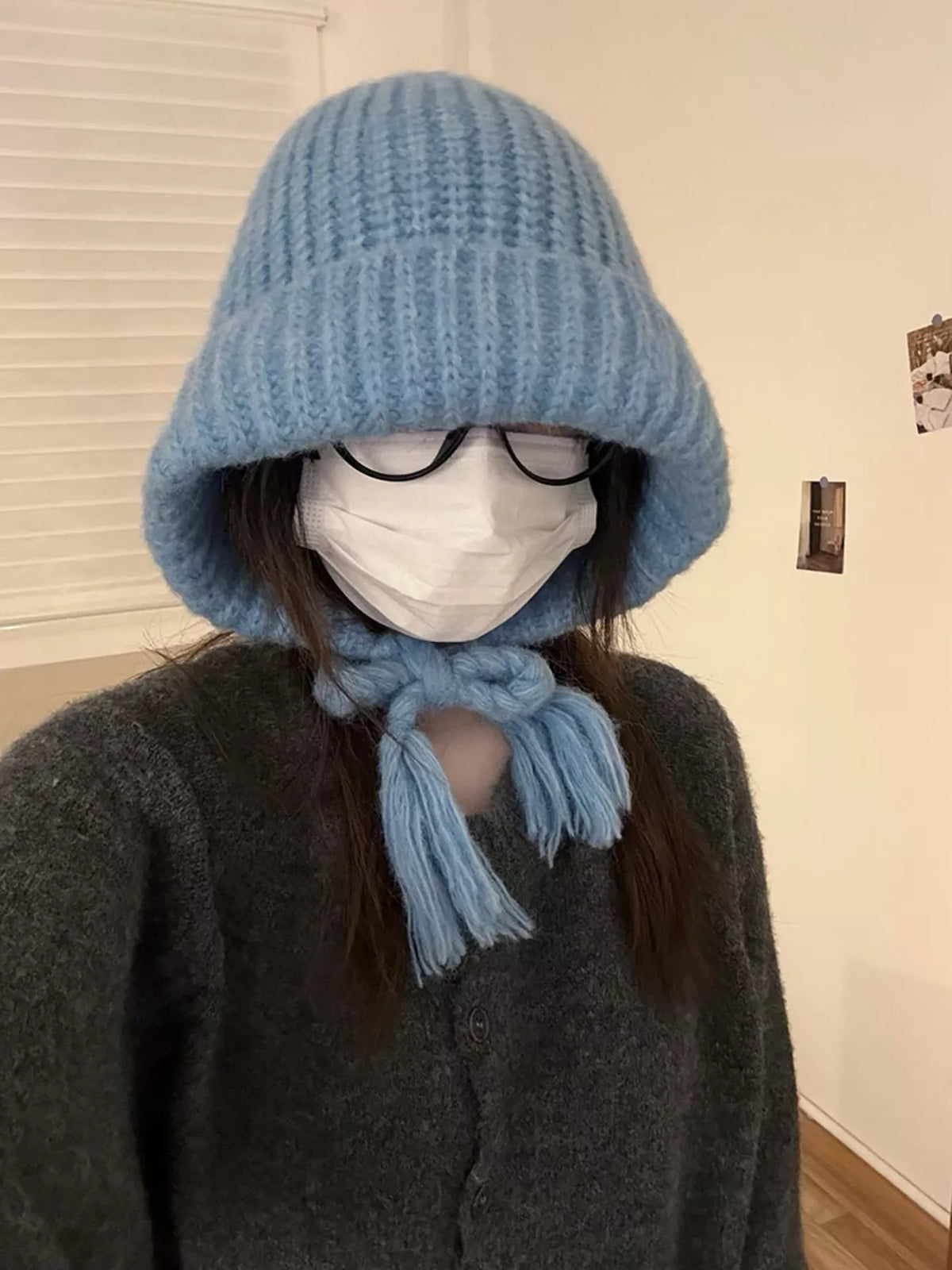 Blue braided beanie with ties fastened beneath the chin