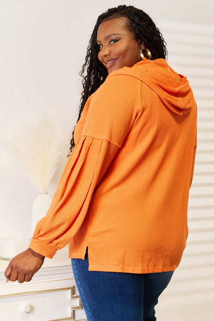 Orange hoodie, rear view showing the side-slit hem