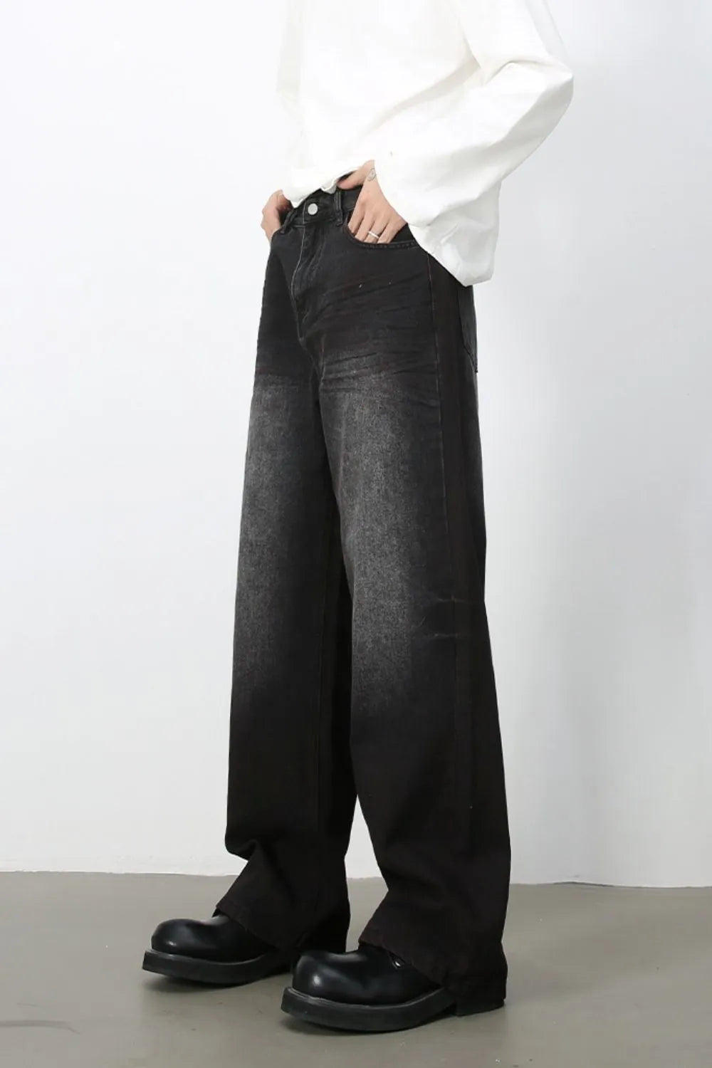 Angled view of men's dark-wash loose-fit wide-leg jeans.