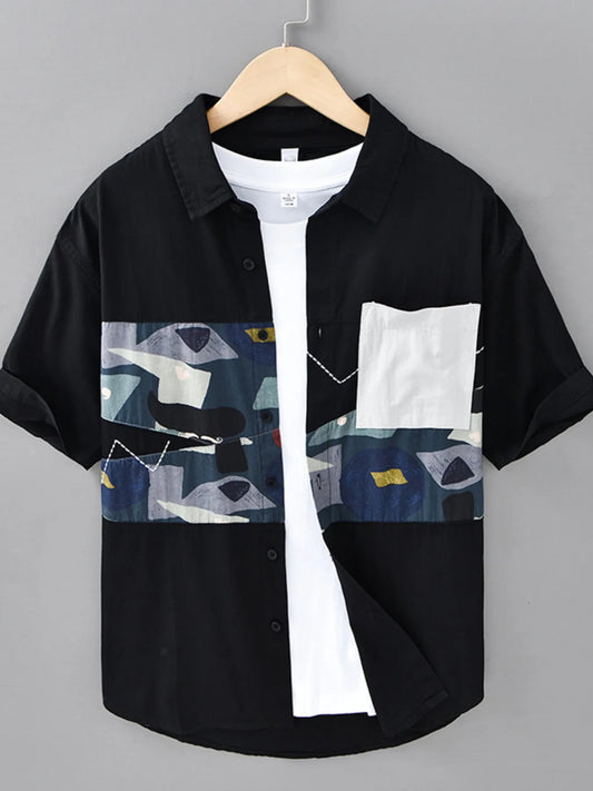 Men's black short-sleeve shirt with abstract chest panel and white pocket, styled over a white undershirt