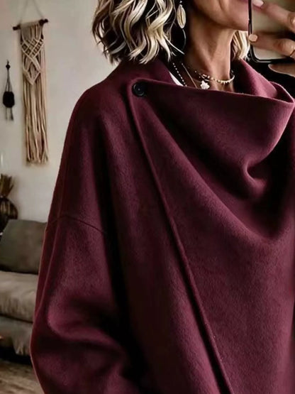 Burgundy asymmetric cowl-neck cape, close-up of the draped neckline and button detail