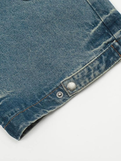 Close-up of a jeans leg hem with an open snap fastening.