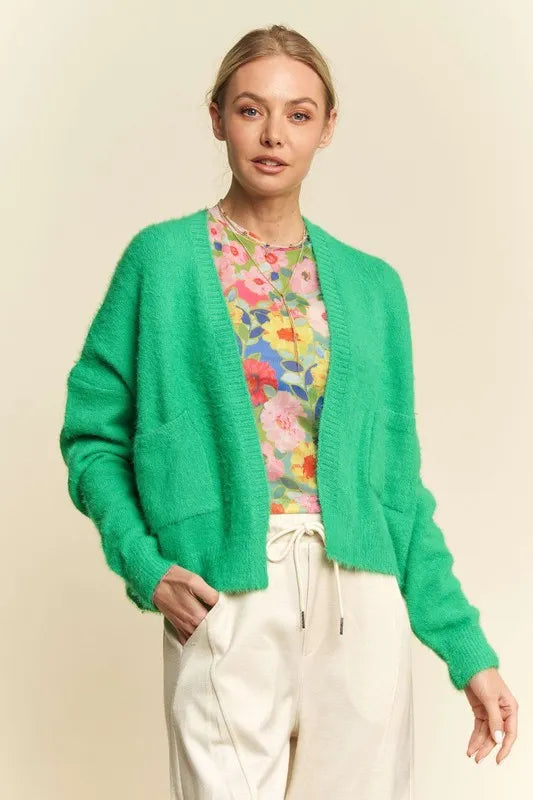 Green open-front cardigan, front view over a floral top.
