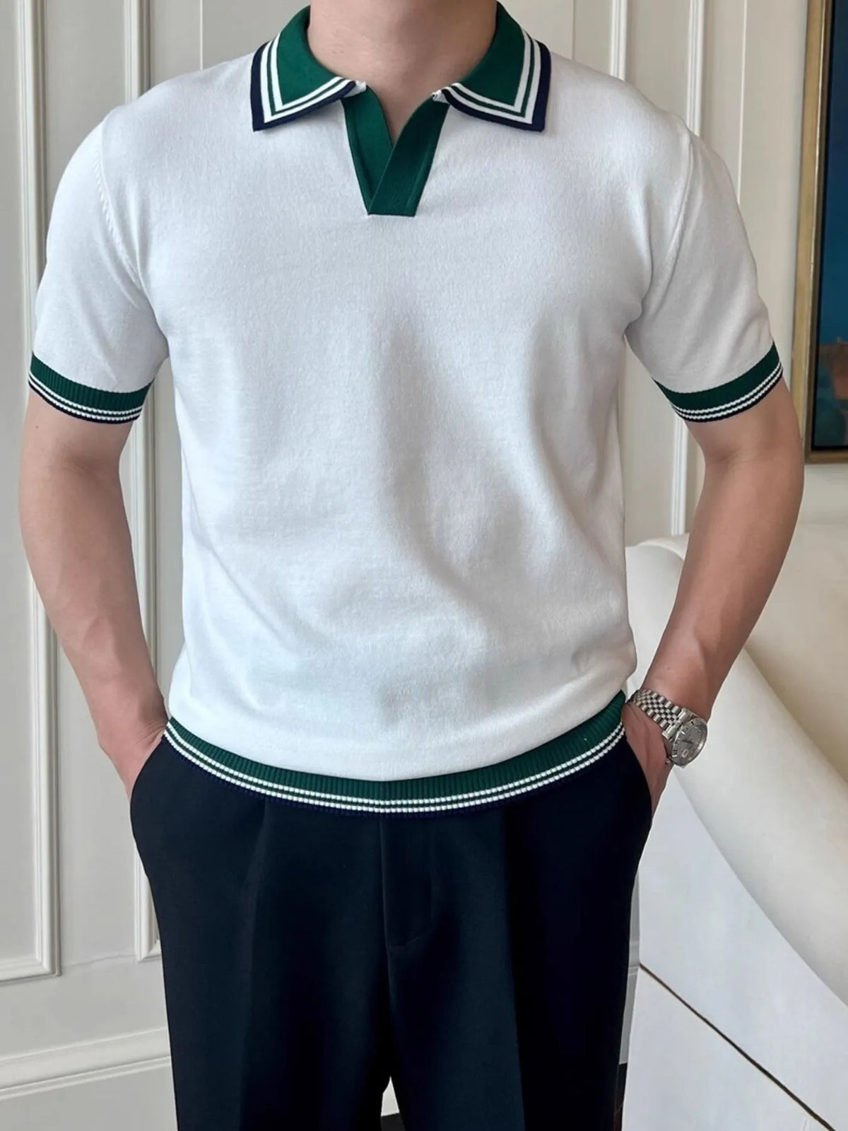 White knit polo with striped collar, sleeve bands and ribbed hem, worn on a model.
