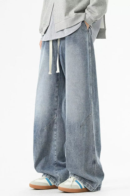 Vintage Blue men's washed wide-leg jeans with front pockets and contrast panel seams, side-front view.