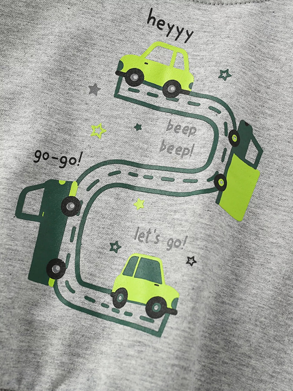 Close view of the green cars and winding-road graphic on the gray sweatshirt.