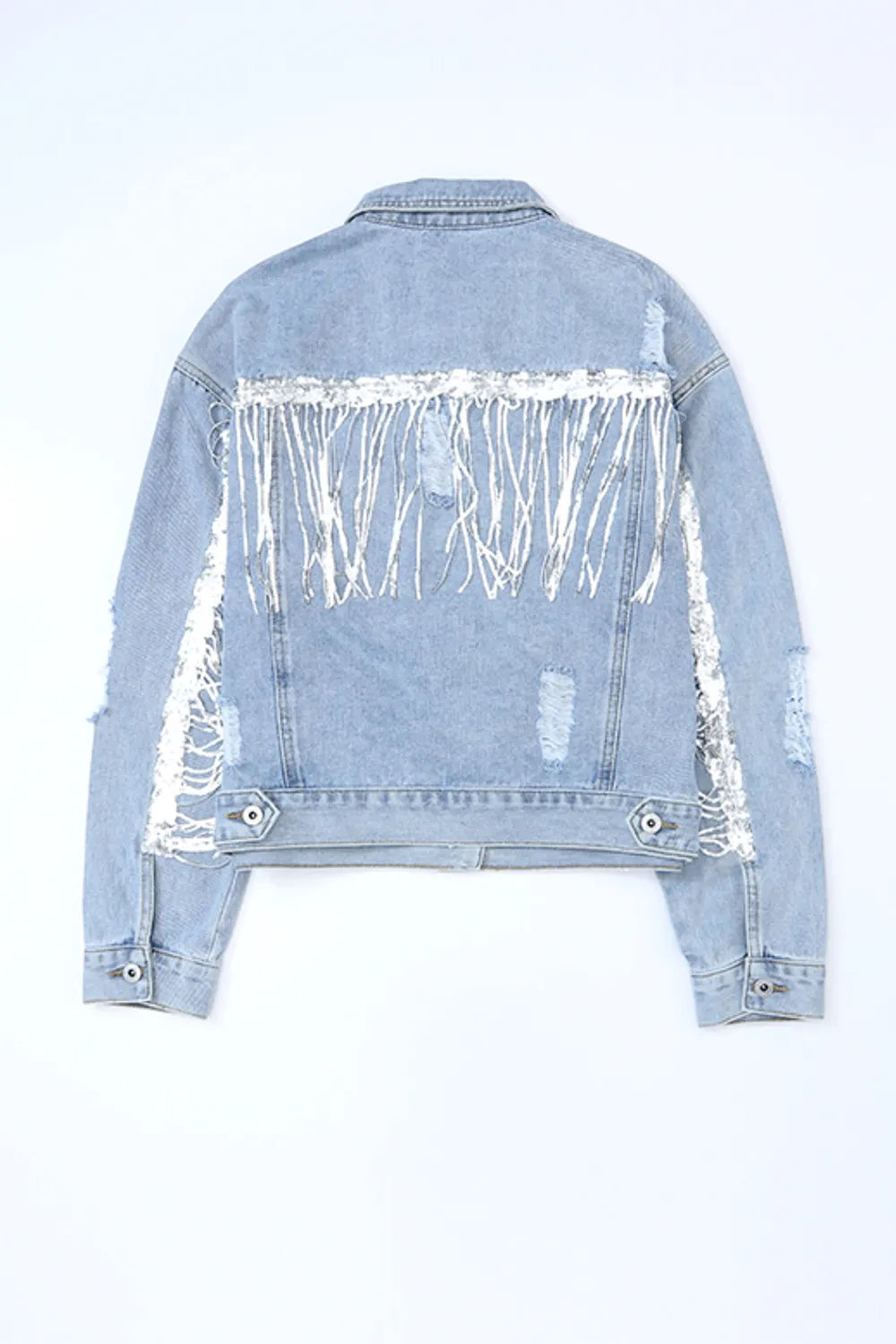 Blue denim jacket laid flat, back view showing silver sequin fringe across the shoulders and sleeves and buttoned hem tabs.