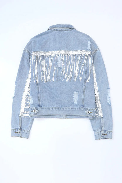 Blue denim jacket laid flat, back view showing silver sequin fringe across the shoulders and sleeves and buttoned hem tabs.