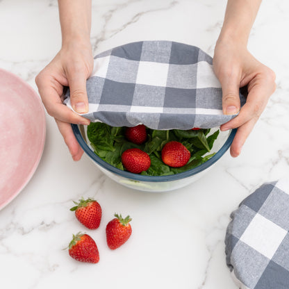 Gray and white checked cover stretched over a berry bowl