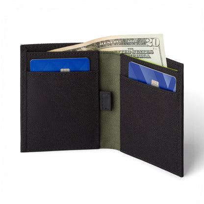 Black COR Surf bifold wallet open, showing card pockets and cash sleeve; cash and cards are display props.