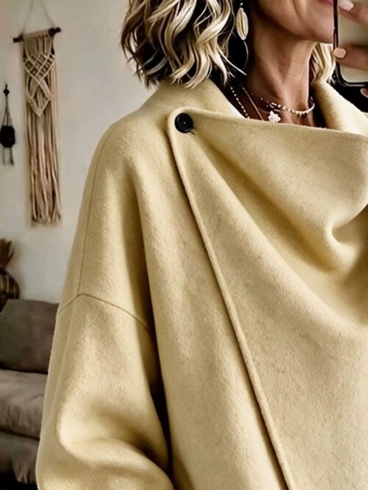 Light Yellow asymmetric cowl-neck cape, close-up of the draped neckline and button detail