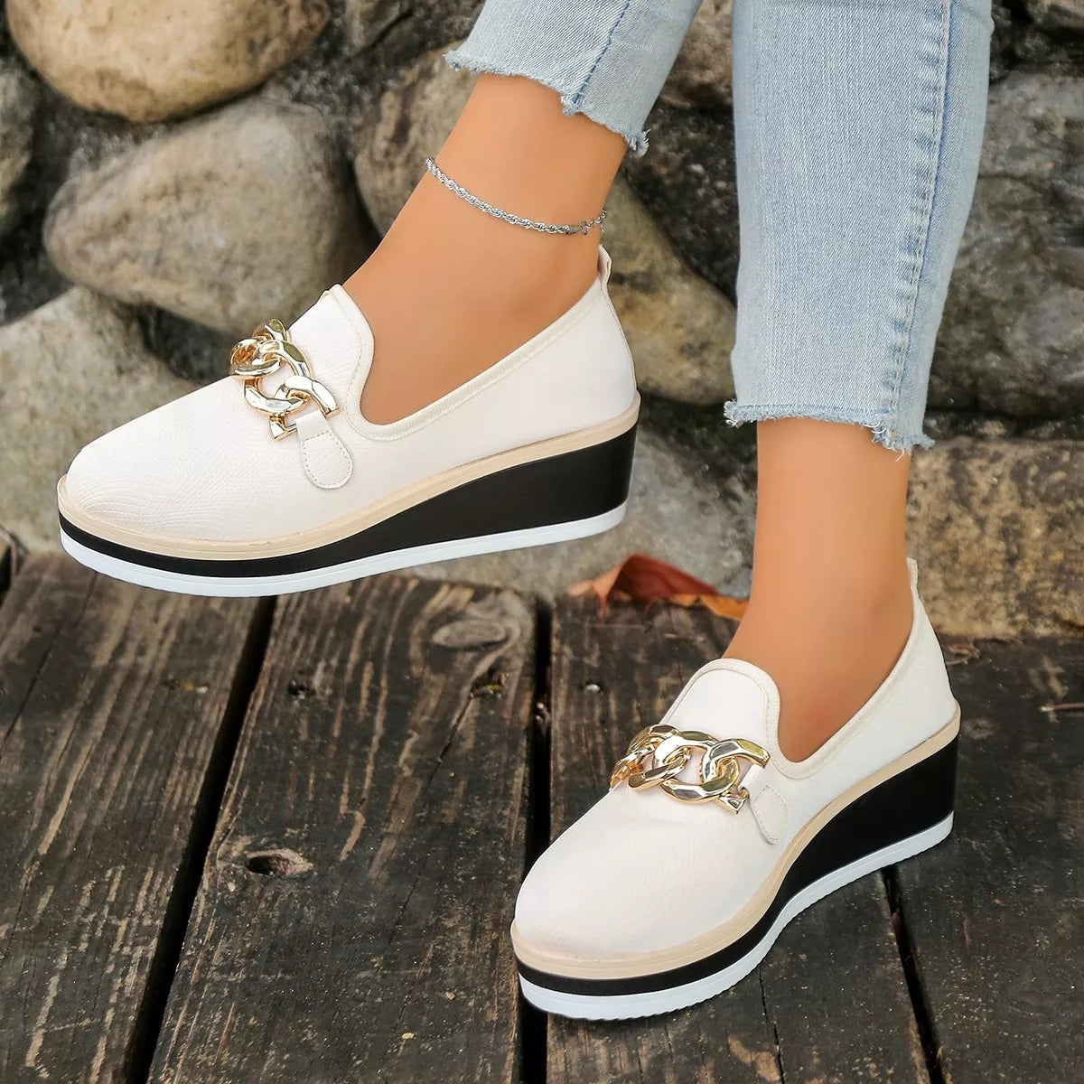 Beige round-toe wedge loafers viewed from the side while worn.