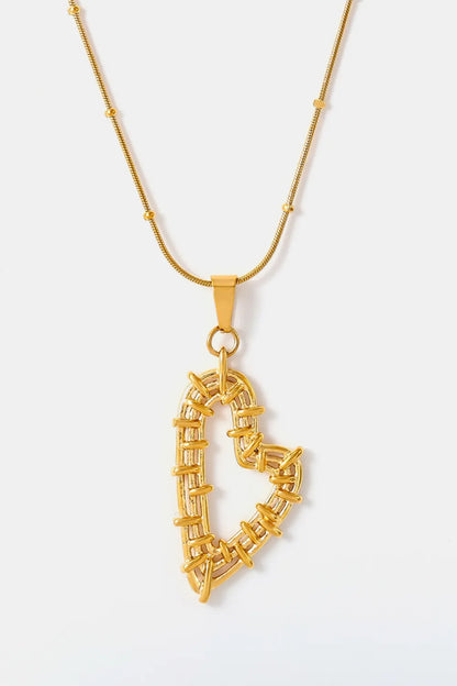 Gold-tone necklace with an open wrapped-wire heart pendant on a pale background.
