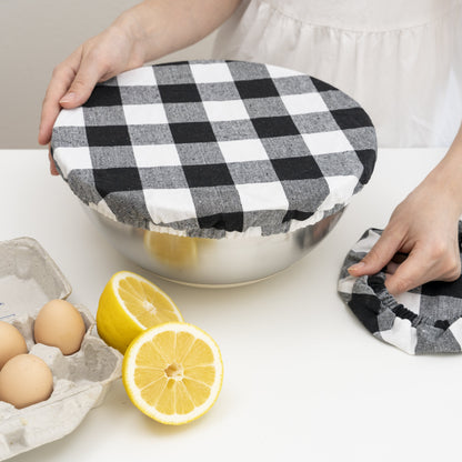 Black and white checked elastic cover being fitted over a bowl