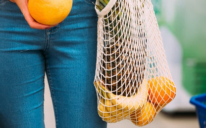 Cotton mesh shopping bag carried with produce; contents not included