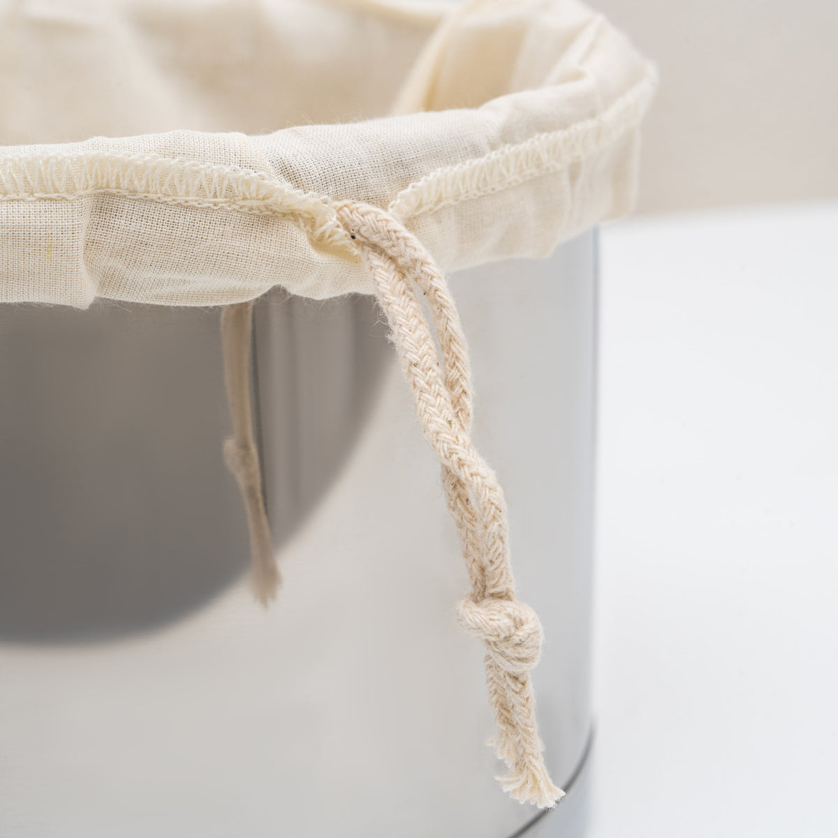 Drawstring and cotton fabric detail on a straining bag