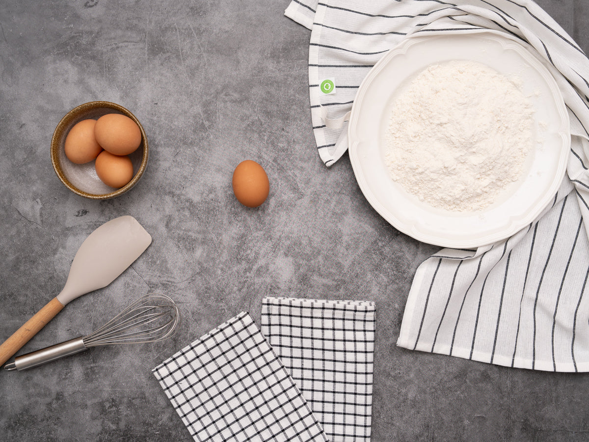 Striped and checked cotton kitchen towels beside baking ingredients; food and tools not included