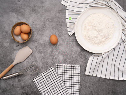 Striped and checked cotton kitchen towels beside baking ingredients; food and tools not included