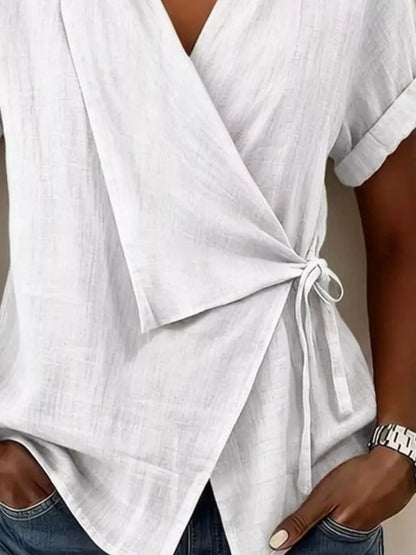 White wrap top detail showing the side tie and overlapping pointed hem panels.