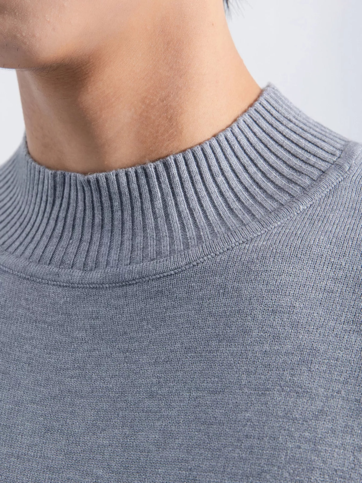 Men's Gray minimalist mock-neck sweater, mock-neck ribbing detail view. Trousers are styling items and are not included.