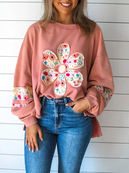 Dusty pink floral applique sweatshirt, front view with round neck and long sleeves. Trousers are styling only.