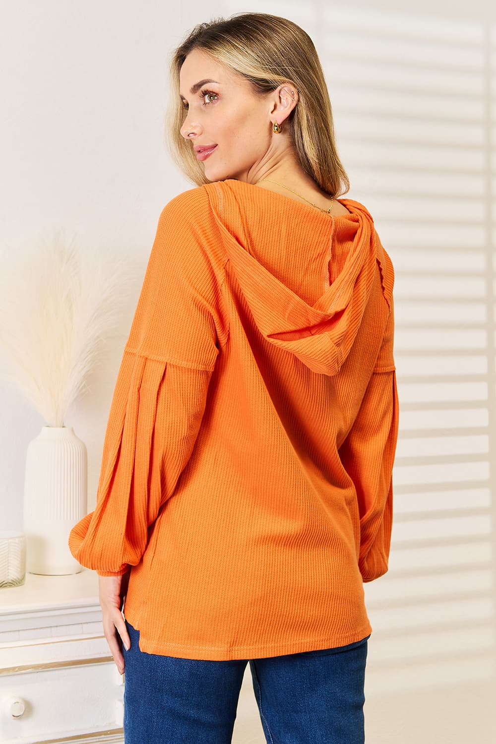 Orange waffle-knit hoodie, rear view showing the hood