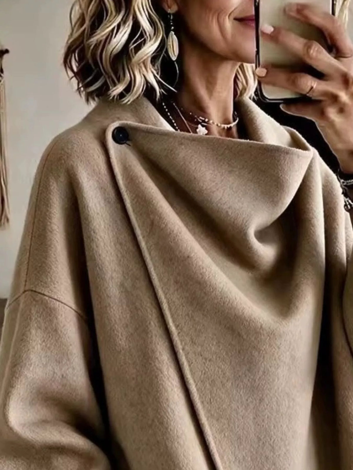 Khaki asymmetric cowl-neck cape, close-up of the draped neckline and button detail