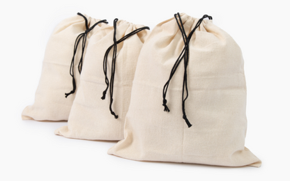 Three natural cotton storage bags with black drawstring ties.