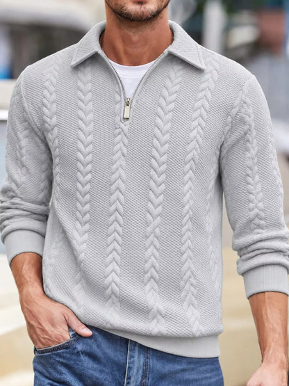 Men's light-gray cable-textured quarter-zip pullover with pointed collar and ribbed cuffs and hem, shown on a model.