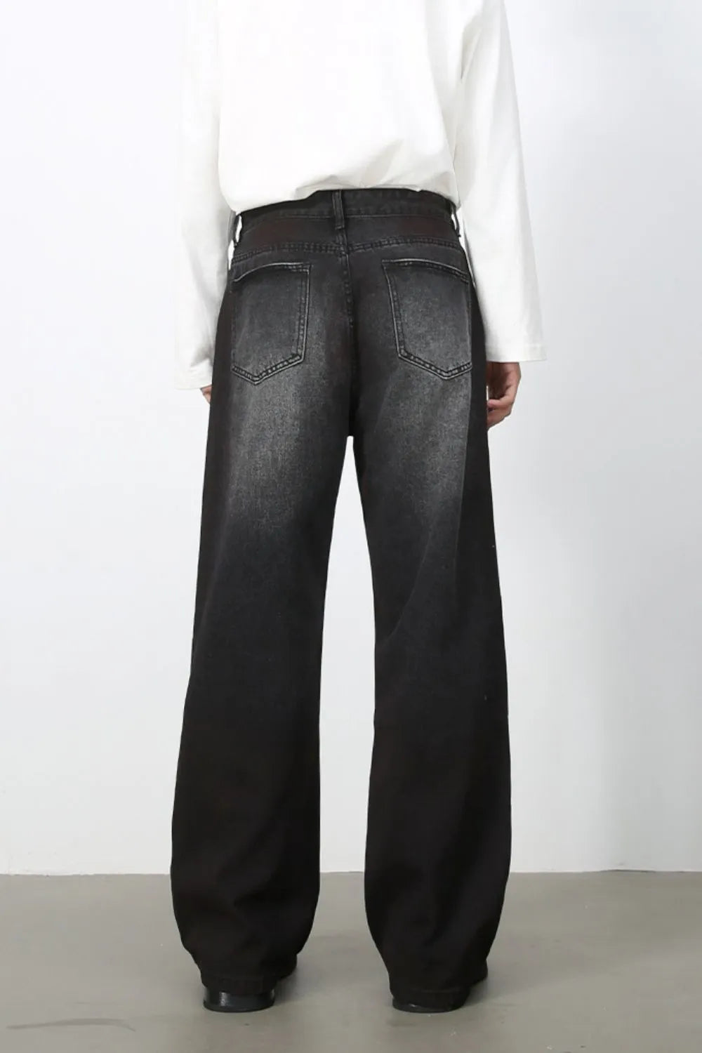 Back view of men's dark-wash loose-fit jeans and rear pockets.