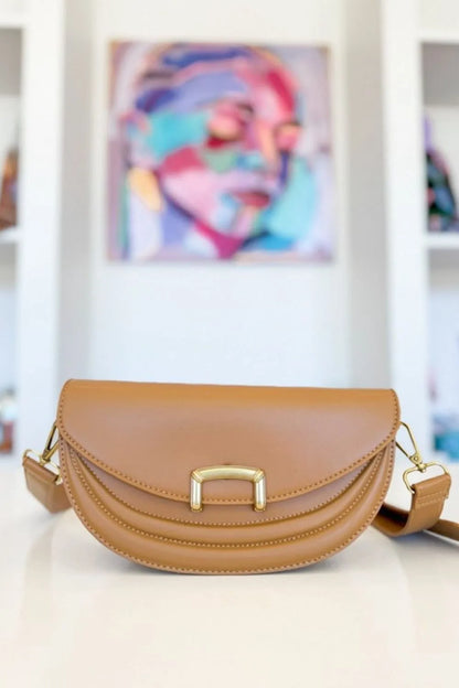 Camel crescent crossbody bag with gold-tone buckle detail, front view
