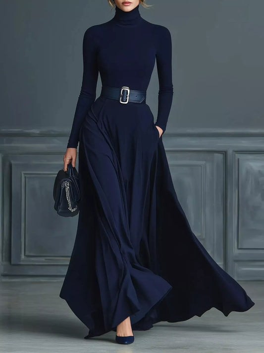 Full-length front view of the navy turtleneck long-sleeve maxi dress with a flared skirt and side pockets. Styling belt, bag and shoes are not included.