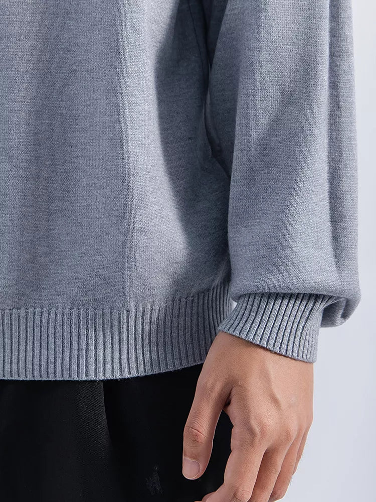 Men's Gray minimalist mock-neck sweater, cuff and hem ribbing detail view. Trousers are styling items and are not included.