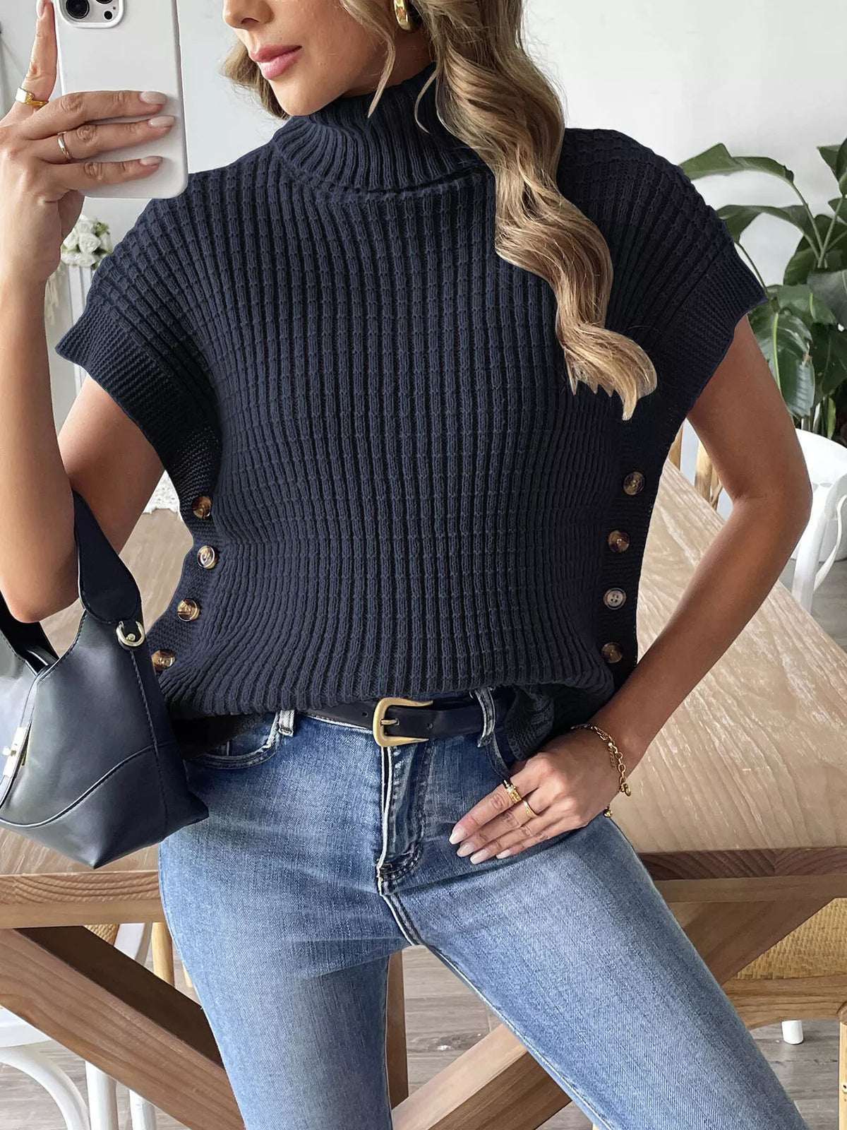 Navy Blue ribbed turtleneck sweater vest, styled tucked at the waist; jeans and bag not included.