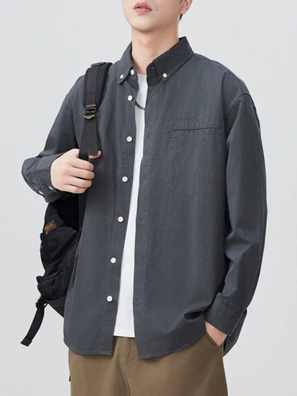 Grey long-sleeve shirt open over a white T-shirt, front view with bag strap