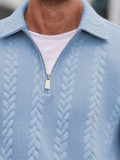 Close view of the light-blue pullover's collar, short zipper and cable-textured knit.