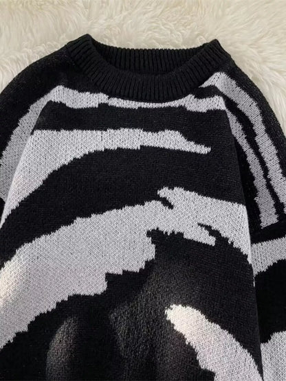 Upper-front detail of the black and light-gray patterned round-neck sweater.