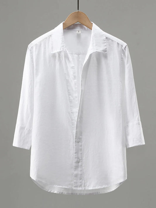 White button-up shirt on a hanger, front view showing a pointed collar, buttoned cuffs and curved hem.