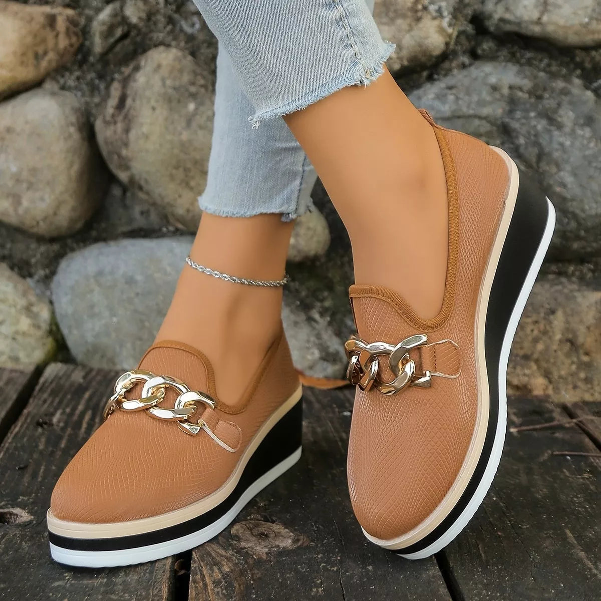 Brown slip-on wedge loafers viewed from the side while worn.