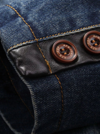 Close-up of the blazer's cuff buttons, dark trim and contrast stitching.