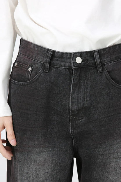 Close-up of the dark-wash jeans' front waist and pockets.